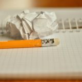 言情小说编辑顾南亭在夜间台灯下阅读稿件，纸页与钢笔摆放整齐